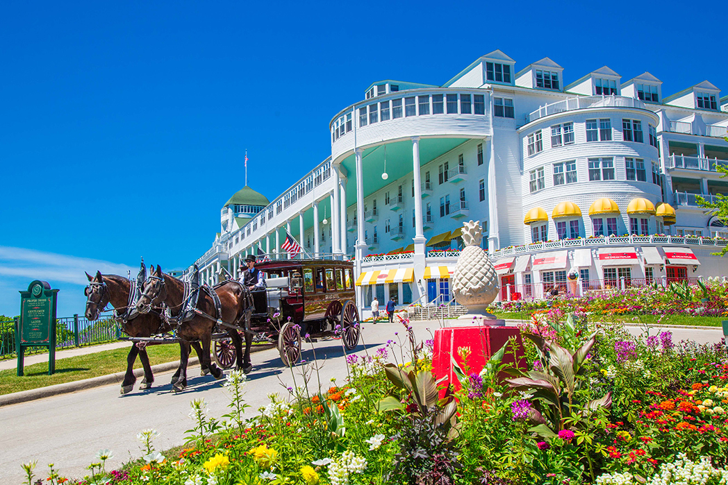 Image of the exterior of the Grand Hotel with horse-drawn carriage. Grand Hotel, a member of Historic Hotels since 2001, dates to 1886. It is located in Mackinac Island, Michigan.